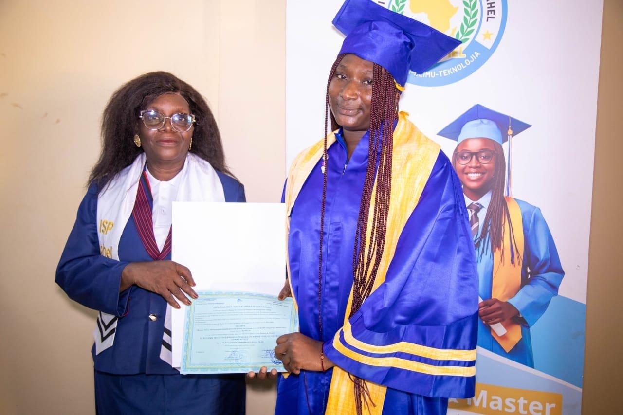 Une représentante de l'ISP SAHEL remet son diplôme de Licence professionnelle à une diplômée en toge bleue
