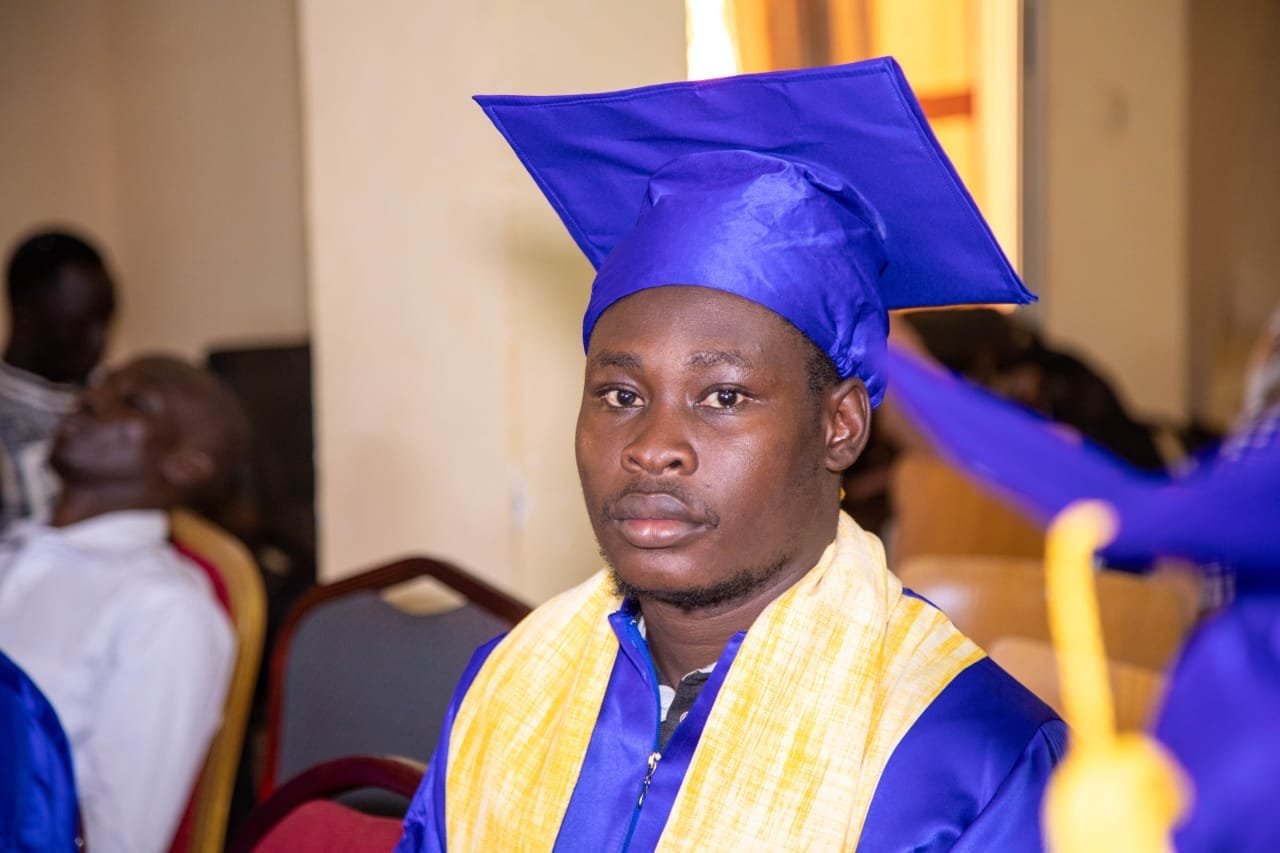 Un jeune diplômé en toge bleue et étole jaune pendant la cérémonie
